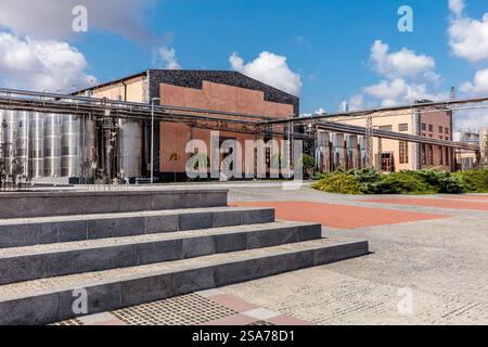 Ein Gebäude mit einem großen Dach und einer Treppe, die hinauf führt. Das Gebäude ist von einem gemauerten Gang umgeben Stockfoto