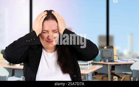 Schöne Geschäftsfrau in schwarzem Anzug im Büro, die an Kopfschmerzen leidet, verzweifelt und gestresst wegen Schmerzen und Migräne. Hände auf den Kopf. Stockfoto
