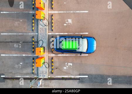 Die grüne Batterieladeanzeige ist auf dem Dach eines Elektrofahrzeugs an einer öffentlichen Ladestation sichtbar. Stockfoto