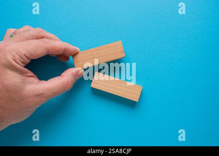Leere Holzblöcke und männliche Hand auf blauem Hintergrund mit Platz zum Schreiben Stockfoto