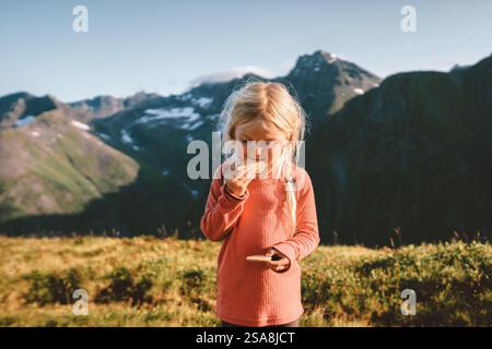 Kind Mädchen essen Cookies Snacks in den Bergen Abenteuer Reise Familienurlaub im Freien aktiv gesunde Lebensweise 4 Jahre alt Kind blonde Haare erforschen Stockfoto