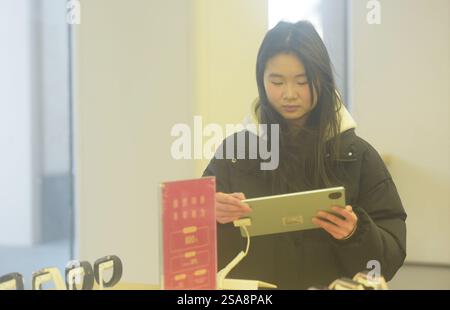 HANGZHOU, CHINA – 29. JANUAR 2025 – Ein Kunde kauft ein neues staatlich subventioniertes Mobiltelefon in einem Huawei-Geschäft in Hangzhou, der ostchinesischen Provinz Zhejiang Stockfoto