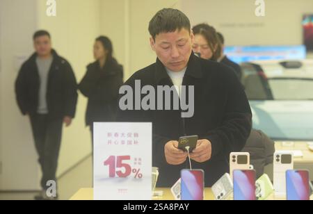 HANGZHOU, CHINA – 29. JANUAR 2025 – Ein Kunde kauft ein neues staatlich subventioniertes Mobiltelefon in einem Huawei-Geschäft in Hangzhou, der ostchinesischen Provinz Zhejiang Stockfoto