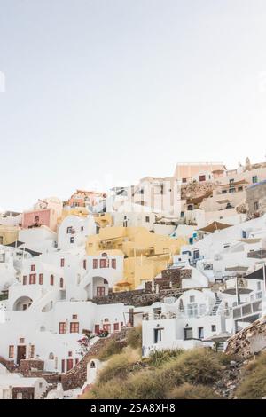 In der Küstenstadt Oia in Santorin, Griechenland, machen die weiß getünchten Häuser und Kuppeldächer das Küstendorf berühmt für seine Architektur. Stockfoto