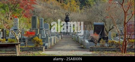 Blick auf den Friedhof von Tokuunin, einem buddhistischen Tempel im Westen von Tokio, mit farbenprächtigem Herbstlaub, das überall sichtbar ist Stockfoto