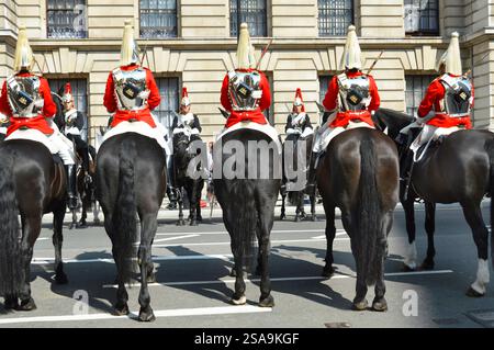 Rückansicht Soldaten und Pferde des roten Life Guards Regiment Changing Guard Zeremonie gegen Blues & Royals-Truppen, beide Haushalts-Kavallerie in London, Großbritannien Stockfoto