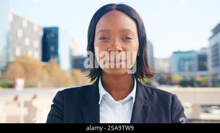 Selbstbewusste Geschäftsfrau, die sich im Freien in moderner City-Umgebung ausgibt Stockfoto