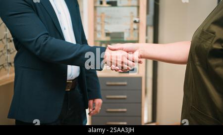 Professioneller Handshake zwischen Optiker und Geschäftseigentümer in einer modernen Büroumgebung Stockfoto