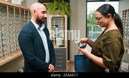 Kunde erhält Brillen vom professionellen Optometristen im Büro Stockfoto