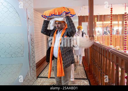 Nach einem Morgengottesdienst, bei dem die gesamte Sikh-Bibel gelesen wird, bringen die Gläubigen sie in einen Raum, in dem sie gelagert sind. In Queens, New York. Stockfoto