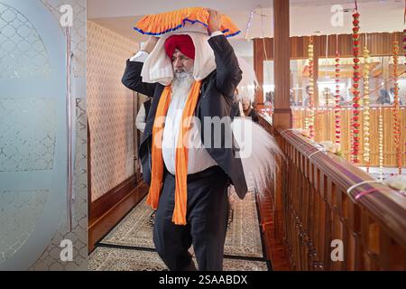 Nach einem Morgengottesdienst, bei dem die gesamte Sikh-Bibel gelesen wird, bringen die Gläubigen sie in einen Raum, in dem sie gelagert sind. In Queens, New York. Stockfoto