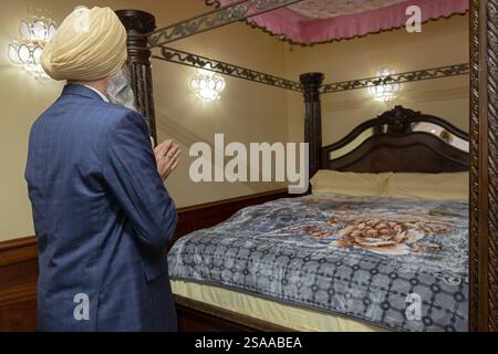 Nachdem die Sikh-Bibeln aufbewahrt wurden, betet ein angesehener Mann mit gefesselten Händen. In einem Tempel in South Richmond Hill, Queens, New York. Stockfoto