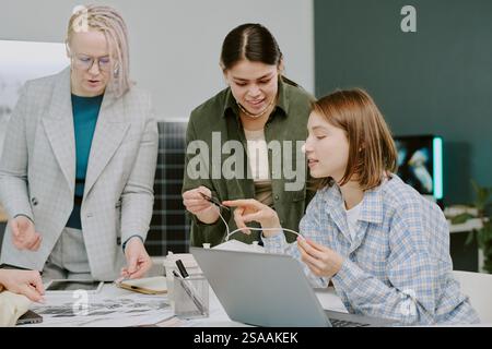 Gruppe von Fachleuten arbeitet zusammen, prüft Dokumente und diskutiert Ideen im Büro in einer gemeinsamen Atmosphäre mit verschiedenen Teilnehmern, die produktive Gespräche führen Stockfoto