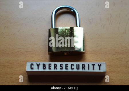 Cybersicherheitskonzept. goldenes Vorhängeschloss mit Wort auf einem hellen Holzblock. Stockfoto
