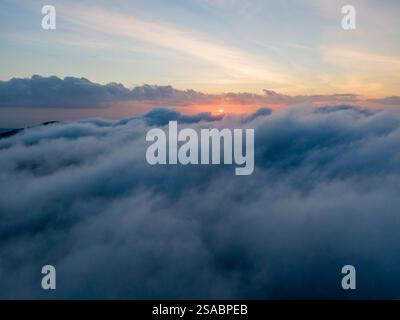 Sonnenaufgang über einem Wolkenmeer, atemberaubender Blick von oben. Stockfoto