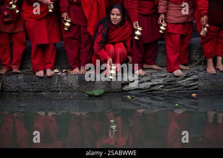Am 29. Januar 2025 in Kathmandu, Nepal. Eine hinduistische Anhängerin wartet darauf, Wasser zu füllen, während sie ein religiöses Ritual am Ufer des Flusses Bagmati im Pashupatinath-Tempel durchführt, das ein einmonatiges „Shree Swasthani Brata“-Festival feiert, das der Göttin Swasthani und Gott Madhav Narayan gewidmet ist. Die Rituale, die mit den Swasthani Brata und Madhav Naryan verbunden sind, finden an den Ufern von Flüssen in verschiedenen hinduistischen Schreinen im ganzen Land statt, während die Gläubigen auch das heilige „Swasthani“ zu Hause lesen. (Foto: Abhishek Maharjan/SIPA USA) Credit: SIPA USA/Alamy Live News Stockfoto