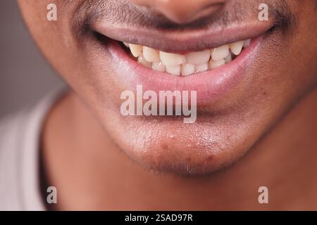 Lächelnder junger Mann mit gesunden Zähnen und Selbstvertrauen Stockfoto