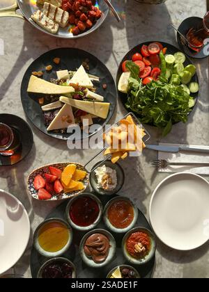 Dieses Foto zeigt eine herrliche türkische Frühstücksszene mit einer Auswahl an lebhaften Gerichten auf einem Marmortisch. Der Aufstrich enthält frisches Gemüse Stockfoto