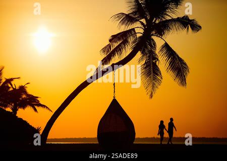 Silhouetten von romantisch zu zweit am tropischen Strand bei Sonnenuntergang Stockfoto