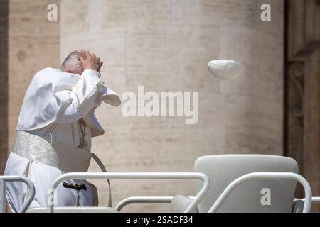 Eine Windböe hebt Papst Franziskus Schädelkappe am Ende seiner wöchentlichen Generalaudienz am 15. Mai 2024 auf dem Petersplatz im Vatikan. Stockfoto