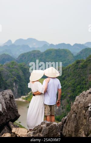 Ein wunderschönes Paar reist gerne durch Südostasien und betrachtet die Aussicht auf die Karstberge und den Fluss der Mua Cave in Vietnam Stockfoto