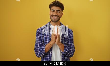 Junger hispanischer Mann, der vor gelbem Hintergrund die Hände klatscht, zeigt Glück und Selbstvertrauen, stilvoll mit Bart in legerer Kleidung gekleidet Stockfoto