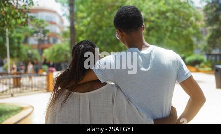 Liebevolle Familie umarmt sich in einem sonnigen Stadtpark und zeigt eine enge Verbindung zwischen einer afroamerikanischen Mutter und ihrem Sohn, während sie die Outdoor-Umgebung genießt Stockfoto