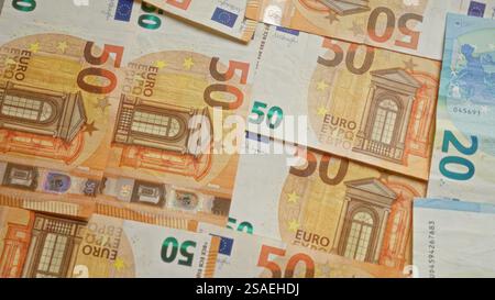 Auf einer Oberfläche verstreute Euro-Banknoten, die verschiedene Stückelungen, darunter 50 und 20 Euro, darstellen, die europäische Währung darstellen, FIN Stockfoto