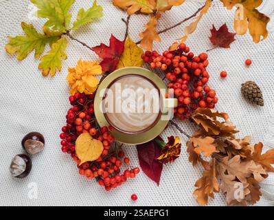 Herbstkomposition. Eine Tasse aromatischen Kaffee umgeben von trockenen Blättern und Beeren. Stockfoto