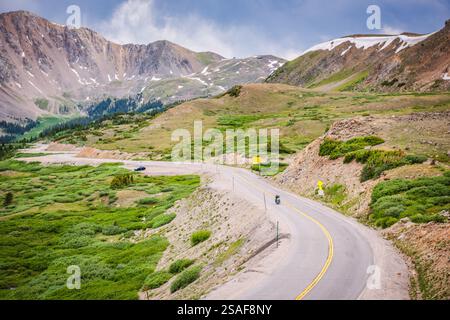 Die U.S. Route 6 schlängelt sich durch den Loveland Pass, einen hohen Bergpass in den Rocky Mountains an einem schönen Frühlingstag mit Schneeteilchen auf dem Gipfel. Stockfoto