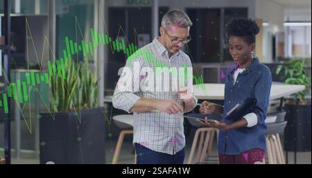 Bild von Diagramm und Datenverarbeitung über verschiedene Kollegen, die im Büro ein Tablet verwenden Stockfoto