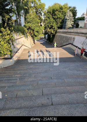 Schatten einer Gruppe von 5 Personen, von der Treppe in einer Stadt aus gesehen; konzeptionell, z. B. oben stehend, nach unten schauend; Silhouetten Stockfoto