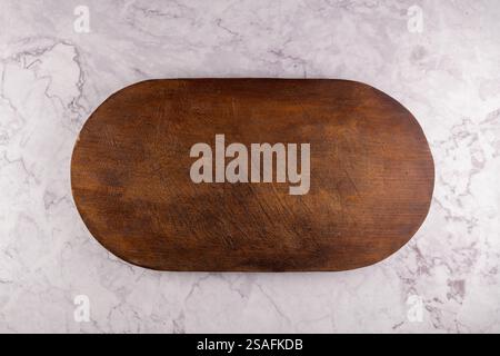 Ovale Holz Schneidebrett auf dunklen konkreten Hintergrund. Ansicht von oben mit der Kopie Platz für Text. Stockfoto