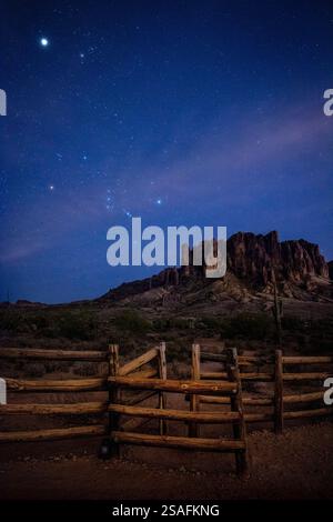 Ein atemberaubender Nachthimmel voller Sterne, darunter der Orion’s Belt, der die Superstition Mountains im Lost Dutchman State Park in Arizona erleuchtet. Stockfoto