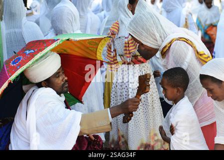 Ein äthiopisch-orthodoxer Priester segnet während der Sonntagsgebete die Gläubigen in einer örtlichen Kirche. Foto in Gondar, Äthiopien. Stockfoto