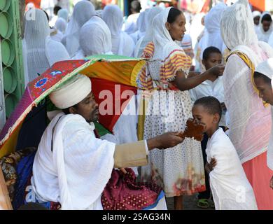 Ein äthiopisch-orthodoxer Priester segnet während der Sonntagsgebete die Gläubigen in einer örtlichen Kirche. Foto in Gondar, Äthiopien. Stockfoto