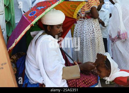 Ein äthiopisch-orthodoxer Priester segnet während der Sonntagsgebete die Gläubigen in einer örtlichen Kirche. Foto in Gondar, Äthiopien. Stockfoto