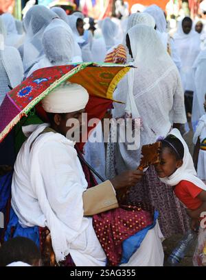 Ein äthiopisch-orthodoxer Priester segnet während der Sonntagsgebete die Gläubigen in einer örtlichen Kirche. Foto in Gondar, Äthiopien. Stockfoto