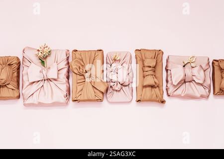 Geschenkboxen in Stoffverpackung, die in einer Reihe angeordnet werden. Stockfoto