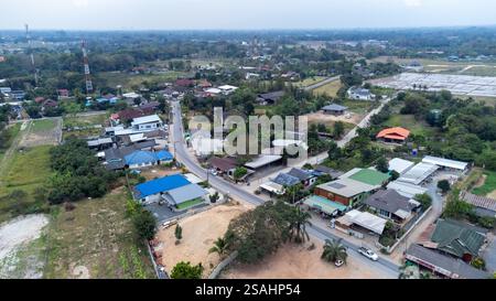 Aus der Vogelperspektive zeigt ein Vorstadtviertel im Norden Thailands mit verschiedenen architektonischen Stilen, umgeben von üppigem Grün und offenem Spa Stockfoto