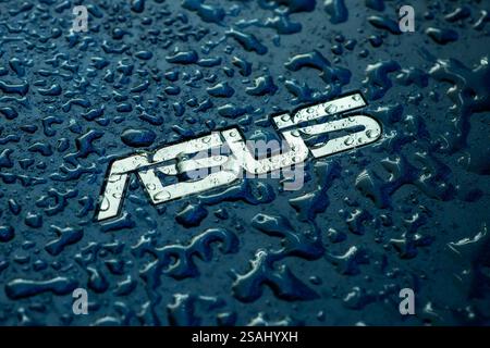 UKRAINE, DNEPR - 02. OKT 2023: ASUS Firmenlogo auf Laptop mit Wassertropfen. Stockfoto