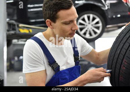 Mechaniker steuert die Profiltiefe der Reifen Stockfoto