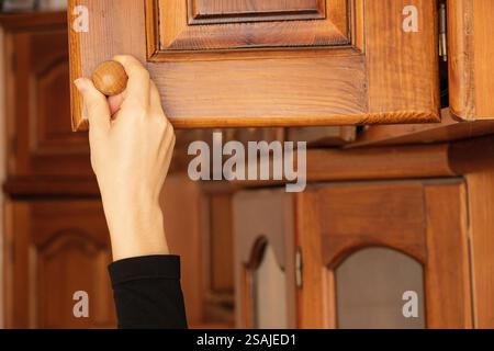 Frau Hand öffnet alten Holzschrank im Schlafzimmer zu Hause, alte Möbel Stockfoto