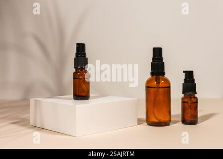 Pumpe bernsteinfarbene Glaskosmetikflasche mit Creme oder Flüssigkeit für Hautpflege auf weißem Betonpodium auf rosa Hintergrund. Natürliches Hautpflegekonzept. Stockfoto