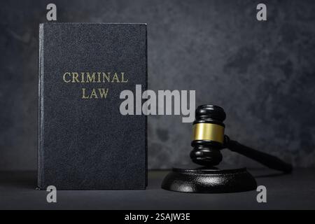 Richter-Hammer, Buch Strafrecht und Handschellen auf grauem Hintergrund. Stockfoto