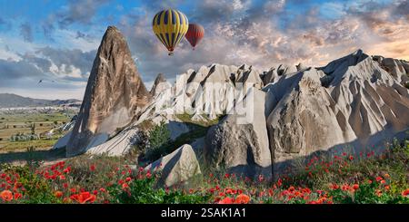 Heißluftballons fliegen Touristen über die spektakulären weltberühmten Felsformationen bei Sonnenaufgang, in der Nähe von Goreme, Kappadokien, Türkei. Stockfoto