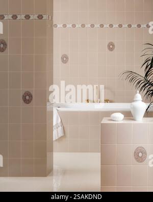 Elegantes Bad mit Badewanne, Goldarmaturen, Handtuch, Seifenschale und weißen Keramikamphoren und gefliesten Wänden Stockfoto