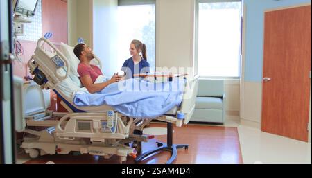 Krankenschwester Oder Arzt Mit Stethoskop, Der Mit Männlichem Patienten Im Privaten Krankenhausbett Spricht Stockfoto