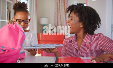Mutter Hilft Der Tochter, Die Tasche Für Die Schule Im Schlafzimmer Zu Hause Zu Packen Stockfoto
