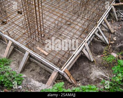 Fundamentarbeiten mit Bewehrungsgitter und Holzschalung für zukünftige Betongießen. Stockfoto